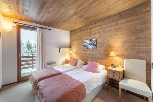 クールシュヴェルにある200m ski slopes - Chalet Manora - Courchevel La Taniaの木製の壁のベッドルーム1室(ベッド1台付)