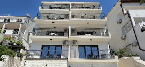 un edificio alto y blanco con balcones. en Villa Dian, en Neum