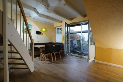 a room with a table and chairs and a staircase at FEWO Seebrise in Flessenow