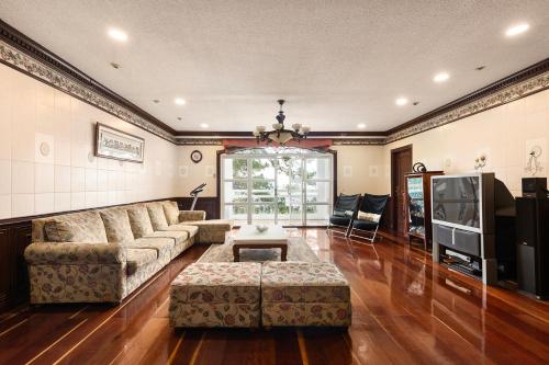 sala de estar con sofá y TV en Villa Moa Baguio, en Baguio