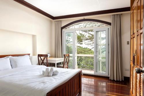 1 dormitorio con cama y ventana grande en Villa Moa Baguio, en Baguio