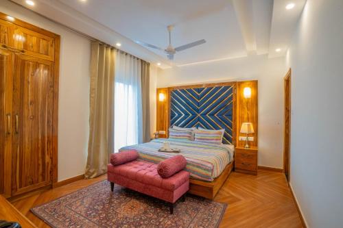 1 dormitorio con 1 cama y 1 silla rosa en PerfectStayz Paradise, en Mussoorie