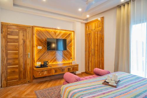 a bedroom with a bed and a flat screen tv at PerfectStayz Value Paradise near Bhatta Falls in Mussoorie
