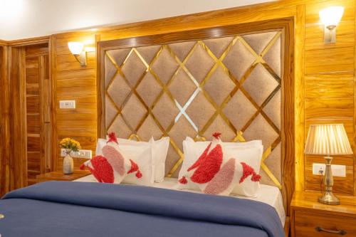 a bedroom with a blue bed with red pillows at PerfectStayz Value Paradise near Bhatta Falls in Mussoorie