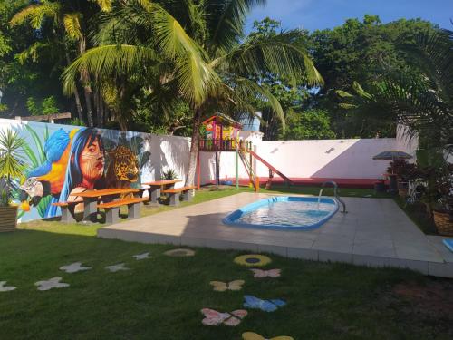 een achtertuin met een zwembad en een speeltuin bij Recanto das Palmeiras Alter do Chão in Alter do Chao