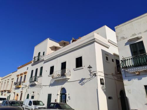 a white building with cars parked in front of it at B&B Punta Cutieri in Gallipoli