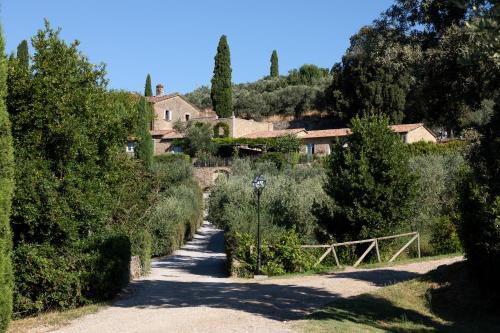 a road leading to a house on a hill with trees at Il Falconiere Relais & Spa in Cortona