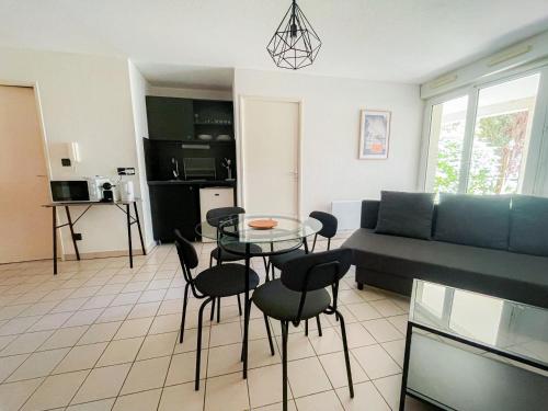 un salon avec un canapé, une table et des chaises dans l'établissement Fox House - Jolie T2 à Saint Orens, à Saint-Orens-de-Gameville