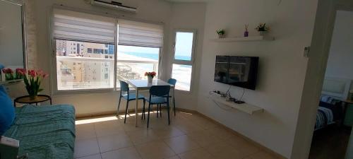 a living room with a table and chairs and a couch at Hotel Apartment TLV-bat yam 81 in Bat Yam