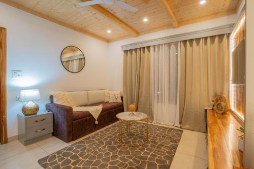 a living room with a couch and a table at PerfectStayz Value Paradise near Bhatta Falls in Mussoorie