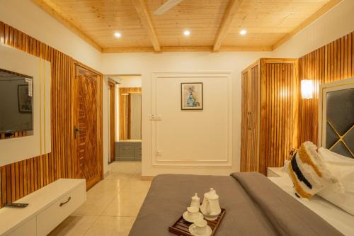 a bedroom with a bed and a tv and a table at PerfectStayz Value Paradise near Bhatta Falls in Mussoorie