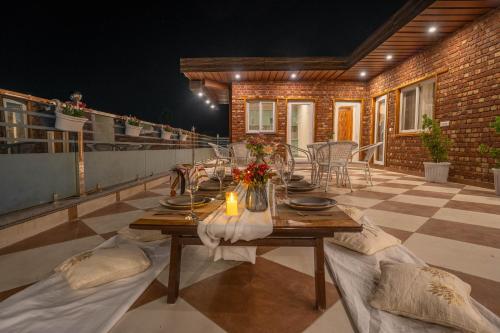 a wooden table on a patio with chairs and a tableablish at PerfectStayz Value Paradise near Bhatta Falls in Mussoorie