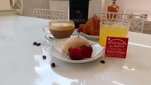 a table with two plates of food and a glass of orange juice at Casa dei Martiri in Altamura