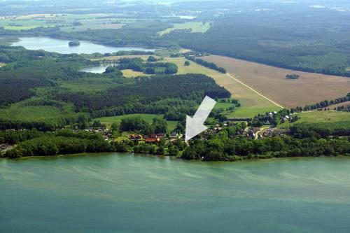 an island in the water with a white triangle on it at FEWO Seekiste Seeufervilla in Flessenow