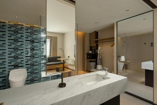 a bathroom with a sink and a toilet and a mirror at Fairfield by Marriott Lijiang Ancient Town in Lijiang