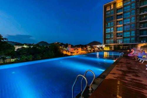 a hotel swimming pool at night with a building at Condo 1 bed in Phuket City Center 8th Floor in Ban Rangeng