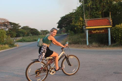 a man riding a bike down a road at Baan sudjai homestay 
