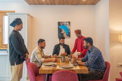 a group of men sitting around a table at PerfectStayz Value Paradise near Bhatta Falls in Mussoorie