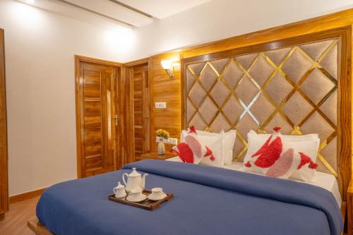 a bedroom with a large bed with a blue bedspread at PerfectStayz Value Paradise near Bhatta Falls in Mussoorie