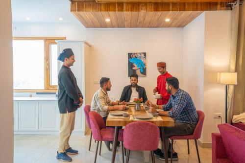 a group of men sitting around a table talking at PerfectStayz Value Paradise near Bhatta Falls in Mussoorie