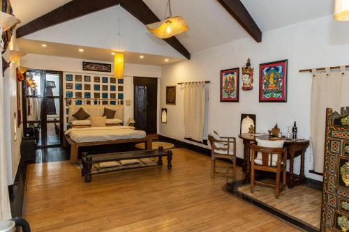 a bedroom with a bed and a table and chairs at Samsara Apartments by Baber Mahal Revisited in Kathmandu