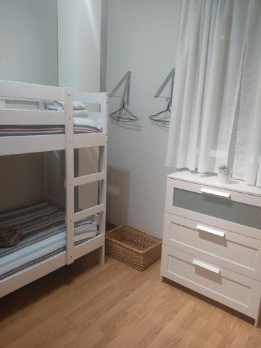 a small bedroom with a bunk bed and a dresser at El Chalet Rosso in Guarnizo