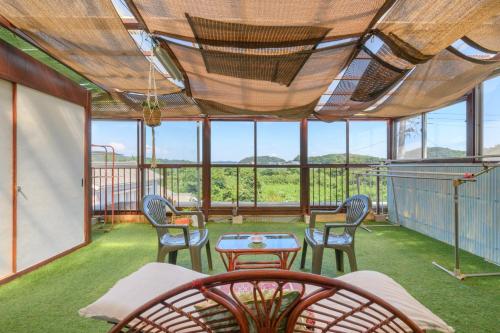 a screened in porch with a table and chairs at OYO Ryokan Hamanako no Yado Kosai - Vacation STAY 48856v in Kosai