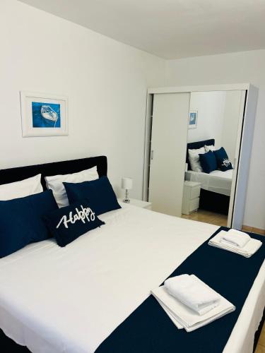 a bedroom with a large bed with blue and white pillows at Hvar beach vacation in Vrboska