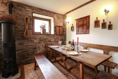 a dining room with a wooden table and a wood stove at Monte Bianco elegant villa apartment Courmayeur in Pré-Saint-Didier