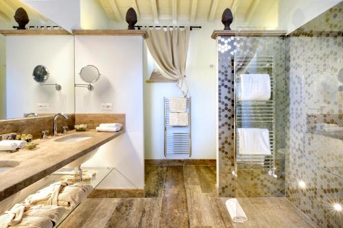 a bathroom with two sinks and a shower at Il Falconiere Relais & Spa in Cortona