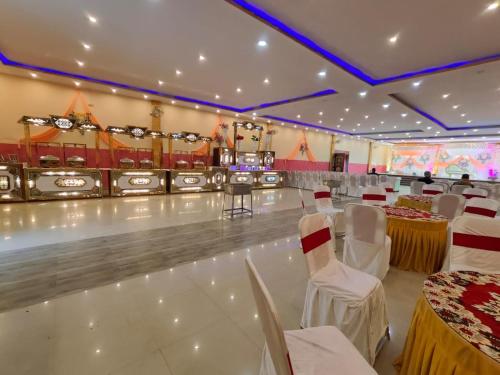 um salão de banquetes com mesas e cadeiras e uma pista de bowling em Raj Resort em Patna