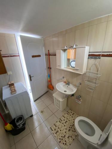 a small bathroom with a toilet and a sink at Pedi’s house in Aspropótamos