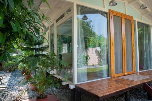 une véranda avec un banc en bois et des plantes dans l'établissement ITH Luxury Family Cottage – Hibiscus, à Varanasi