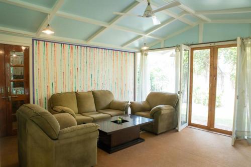 バラナシにあるITH Luxury Family Cottage – Hibiscusのリビングルーム(ソファ、コーヒーテーブル付)