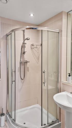 a shower stall in a bathroom with a sink at Sky High Ensuite Bedroom in Shared Apartment in Belfast City Centre in Belfast