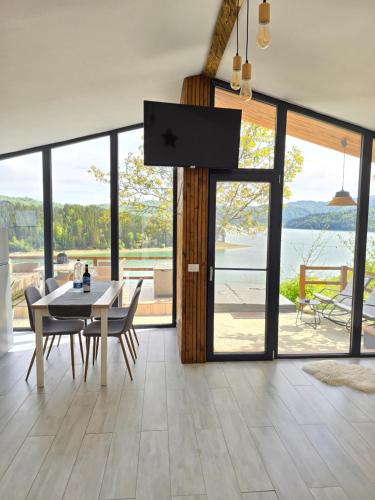 uma sala de jantar com uma mesa e vista para a água em Moon Lake Bicaz em Buhalniţa