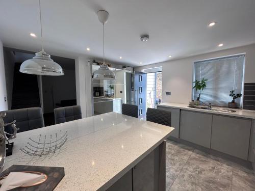a kitchen with a large white island in a room at Westcliff-on-Sea Coach house in Westcliff On Sea