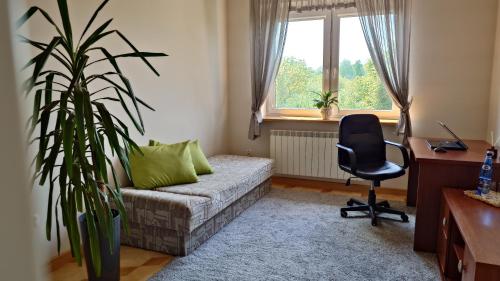 sala de estar con sofá, escritorio y silla en Pokoje u Agnieszki, en Łuków