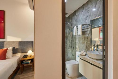 W pokoju znajduje się łazienka z umywalką i toaletą. w obiekcie Én Mansion Hoi An w mieście Hiếu Nhơn