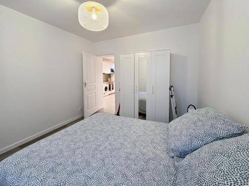 une chambre avec un lit avec une couette bleue dans l'établissement Le Cosy Lagny - Appartement Cosy avec balcon vue sur Marne, à Lagny-sur-Marne