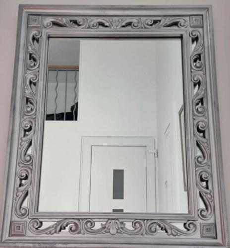 un miroir dans un cadre en argent sur un mur dans l'établissement Appartement proche Disneyland, à Mouroux