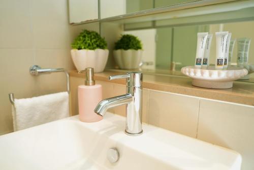 a bathroom sink with a faucet and a mirror at Infinity Lux Apartment in Melbourne