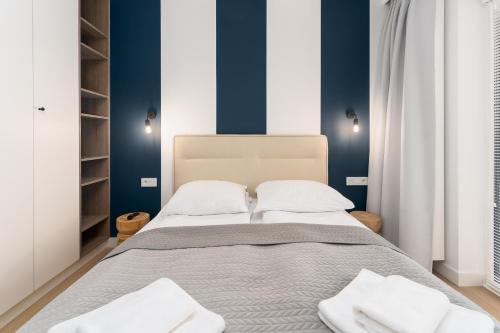 a bedroom with a bed with blue walls at FARO Apartamenty Polanki Aqua SPA Deluxe 4 baseny w cenie, Pools inklusive in Kołobrzeg