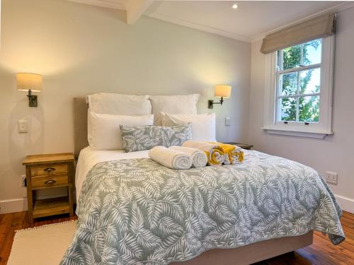 a bedroom with a bed with two towels on it at Valley View Cottages in Cape Town