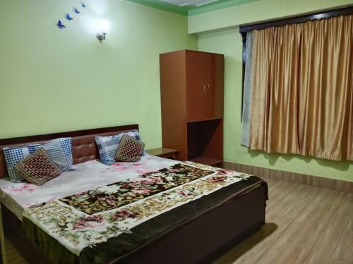 Un dormitorio con una cama grande con flores. en Zimkhang Guesthouse, en Gangtok