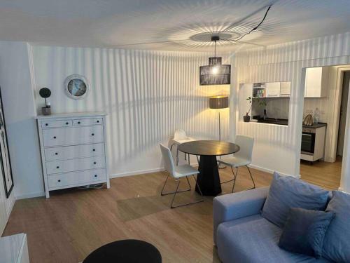 Appartement DUS في دوسلدورف: غرفة معيشة مع أريكة زرقاء وطاولة