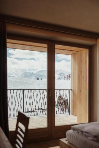 a room with a sliding glass door with a view of a beach at Rifugio Alpino Pralongià in Corvara in Badia