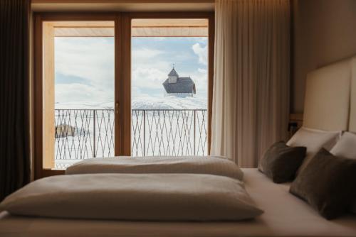 a bedroom with a bed and a window with a view at Rifugio Alpino Pralongià in Corvara in Badia