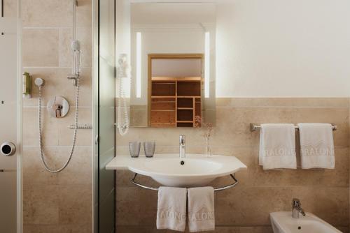 La salle de bains est pourvue d'un lavabo et d'une douche. dans l'établissement Rifugio Alpino Pralongià, à Corvara in Badia