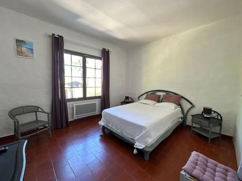 une chambre avec un lit, une chaise et une fenêtre dans l'établissement villa proche corniche avec piscine, à La Teste-de-Buch